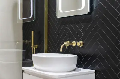a bathroom with a white sink and a black wall at Paisley Road Courtyard in Glasgow