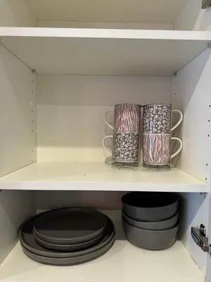 a shelf with plates and bowls in a pantry at Modern Flat in Glasgow City FREE Parking & Wifi in Glasgow