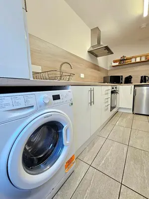 a kitchen with a washing machine in a kitchen at Warm & Cosy Home in Glasgow in Glasgow