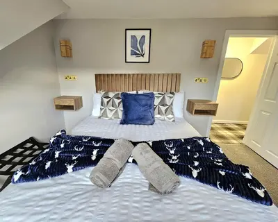 a bedroom with a large bed with blue pillows at Warm & Cosy Home in Glasgow in Glasgow