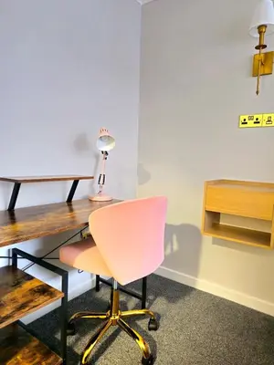 a desk with a pink chair and a lamp at Warm & Cosy Home in Glasgow in Glasgow