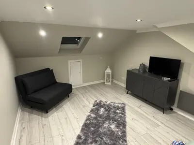 a living room with a chair and a flat screen tv at Caplawhead in Armadale