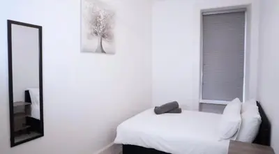 a bedroom with a white bed and a mirror at Newly refurbished 2 bed ! in Glasgow