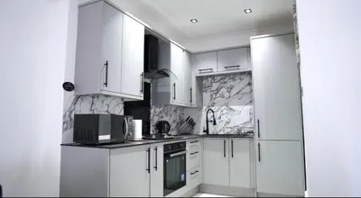 a white kitchen with white cabinets and appliances at Newly refurbished 2 bed ! in Glasgow