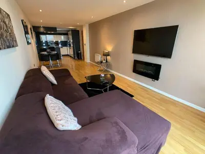 a living room with a couch and a flat screen tv at Glasgow 2bd near Hydro SECC City Centre Great Location in Glasgow