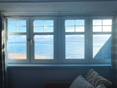 a window with a view of the beach and the ocean at Burlington Guest House in Whiting Bay