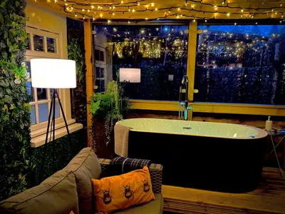a bath tub in a room with a view of a city at Loch Lomond Hideaways- Luxury Cabins with Jacuzzi Hot Tubs for Two in Drymen