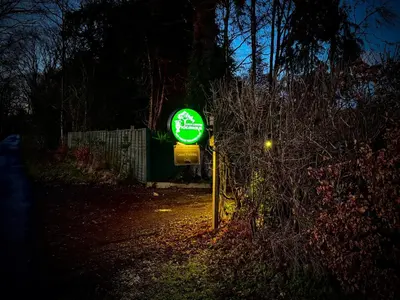a green sign on the side of a road at night at Loch Lomond Hideaways- Luxury Cabins with Jacuzzi Hot Tubs for Two in Drymen