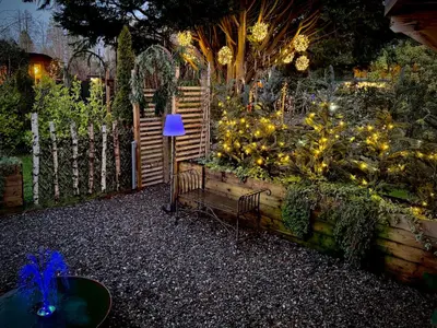 a garden at night with a bench and lights at Loch Lomond Hideaways- Luxury Cabins with Jacuzzi Hot Tubs for Two in Drymen