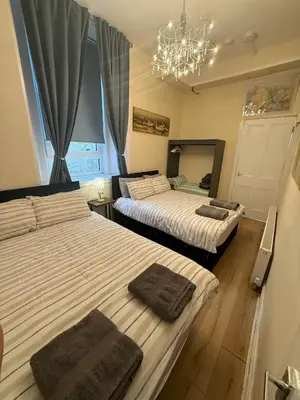 a bedroom with two beds and a chandelier at Flat in Central Edinburgh Old town in Edinburgh