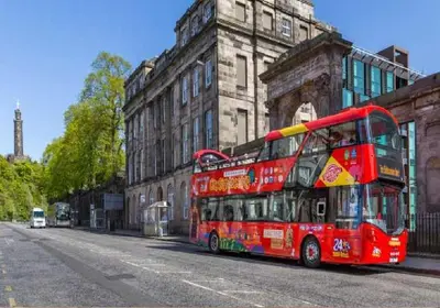 a red double decker bus parked in front of a building at Flat in Central Edinburgh Old town in Edinburgh