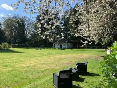 a park with two chairs and a table in the grass at Couples Unique Stay in Bowling Club newly upgraded in Forteviot