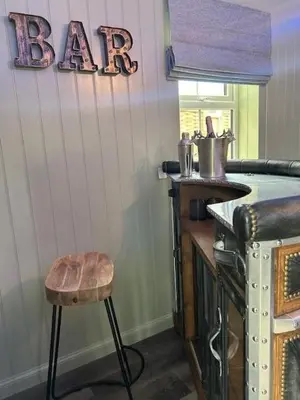 a bar with a stool and a bar sign on a wall at Couples Unique Stay in Bowling Club newly upgraded in Forteviot