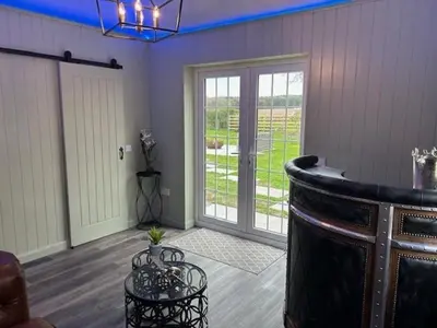 a living room with a large glass door and a table at Couples Unique Stay in Bowling Club newly upgraded in Forteviot