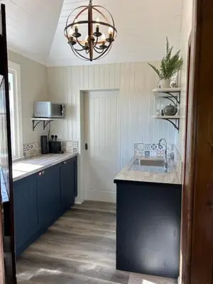 a kitchen with a sink and a chandelier at Couples Unique Stay in Bowling Club newly upgraded in Forteviot