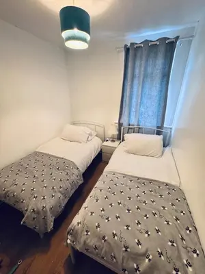two beds in a small room with a window at Bright 3 bedroom house with private garden near Edinburgh - Woodside home in Rosyth