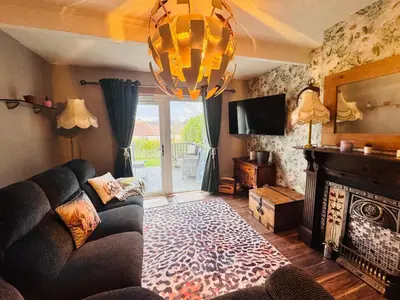 a living room with a couch and a fireplace at Bright 3 bedroom house with private garden near Edinburgh - Woodside home in Rosyth