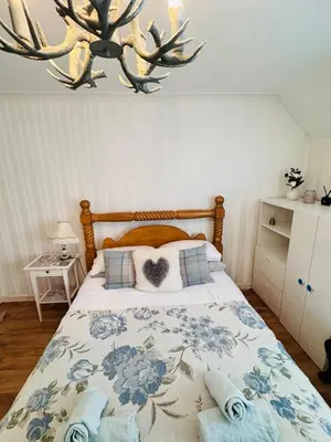 a bedroom with a bed with a heart pillow at Bright 3 bedroom house with private garden near Edinburgh - Woodside home in Rosyth