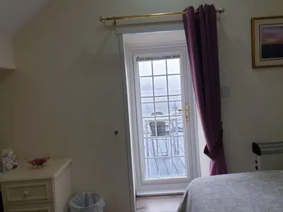 a bedroom with a door leading to a window at Culag Lochside Self Catering in Luss