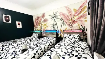 two beds in a room with black and white at Ground Floor Entire Apartment Self Checkin in Crossgates