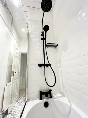 a bath tub with a shower in a bathroom at Ground Floor Entire Apartment Self Checkin in Crossgates