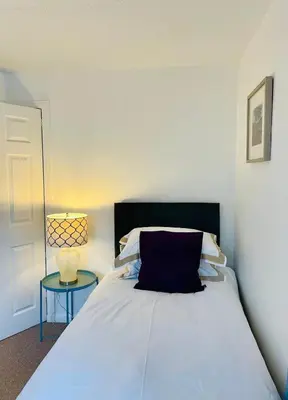 a bedroom with a bed with a blue pillow and a table at A 2 Bedroom flat in Culross home of Outlander in Culross