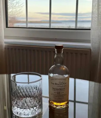 a bottle of whiskey and a glass on a table at A 2 Bedroom flat in Culross home of Outlander in Culross