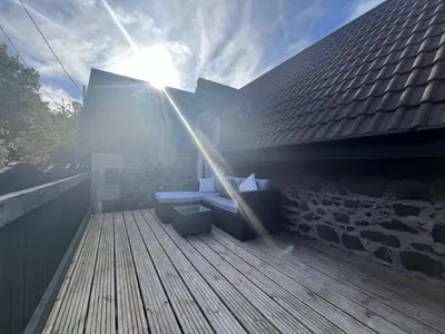 a wooden deck with a bench on top of a building at Dun-Niall Apartment in Oban