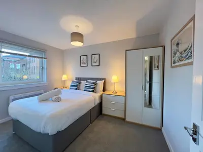 a bedroom with a large bed and a window at Chic & Cozy 2-Bed Flat in Glasgow - Free Parking in Glasgow