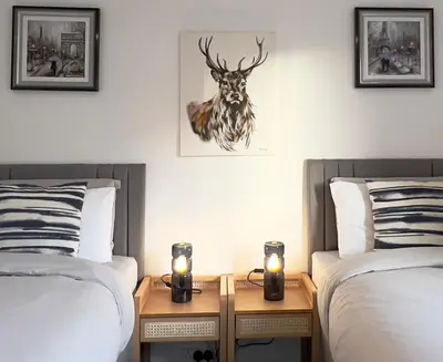 a room with two beds and a deer head on the wall at Chic & Cozy 2-Bed Flat in Glasgow - Free Parking in Glasgow