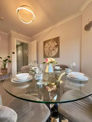 a dining room with a glass table and chairs at Chic & Cozy 2-Bed Flat in Glasgow - Free Parking in Glasgow