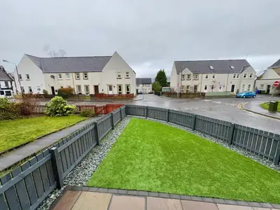 a yard with a fence and green grass at Cochrane House in Stirling