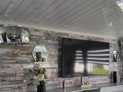 a tv on a brick wall with a television at MLR at Craig Tara Bay View in Ayr