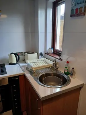 a kitchen counter with a sink and a window at Sunset of Largs in Largs