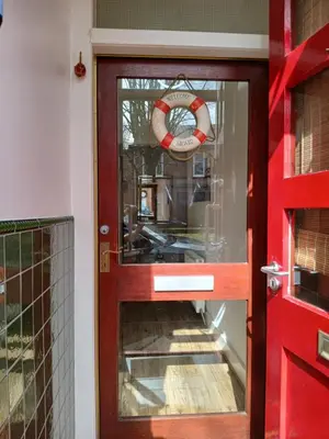 a red door with a life preserver on it at Sunset of Largs in Largs