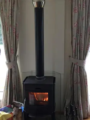a stove in a room with two curtains at Holiday home, Carradale in Carradale