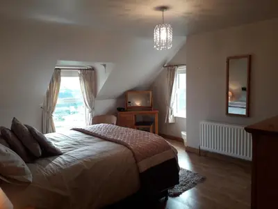 a bedroom with a bed and a television in it at Beachview Cottage Co. Antrim in Cushendun