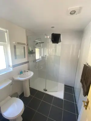 a bathroom with a shower and a toilet and a sink at Beachview Cottage Co. Antrim in Cushendun