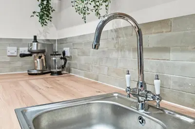 a kitchen sink with a faucet on a counter at Luxury 3 Bedroom Cottage in Centre of Killin in Killin