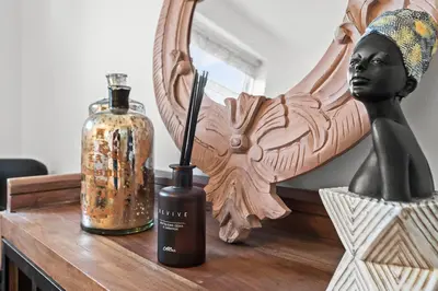 a wooden table with a bottle and a statue on it at Luxury 3 Bedroom Cottage in Centre of Killin in Killin