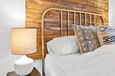 a bed with a metal headboard next to a lamp at Luxury 3 Bedroom Cottage in Centre of Killin in Killin