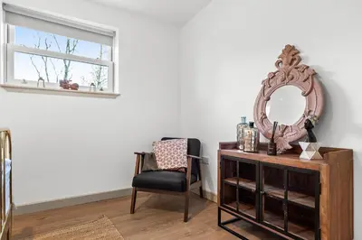 a room with a mirror and a chair and a desk at Luxury 3 Bedroom Cottage in Centre of Killin in Killin
