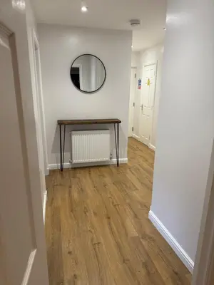 a hallway with a table and a mirror on a wall at Dunfermline 2 Bed Flat Fully Furnished in Dunfermline