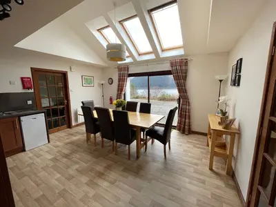 a kitchen and dining room with a table and chairs at Old Springwell Croft in Onich