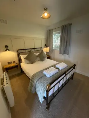 a bedroom with a bed with two towels on it at Old Springwell Croft in Onich