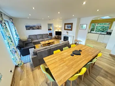 a living room with a table and a couch at Old Springwell Croft in Onich