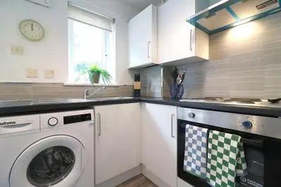 a kitchen with a washing machine and a sink at Signature - Thorn House in Coatbridge