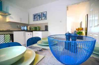 a table with blue bowls and plates on it at Signature - Thorn House in Coatbridge
