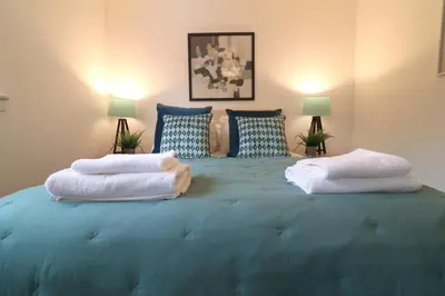 a large blue bed with two pillows on it at Signature - Thorn House in Coatbridge