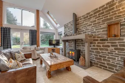 a living room with a brick wall at Scenic Oaklodge with wood burner in Saint Fillans